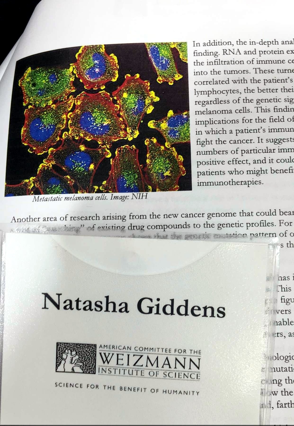 Guest badge reading Natasha Giddens, American Committee for the Weizmann Institute of Science, Science for the benefit of humanity, resting on an open Institute brochure
